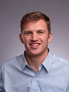 Man with blue shirt against white/grey background