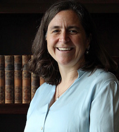 Woman in blue sweater with books in background