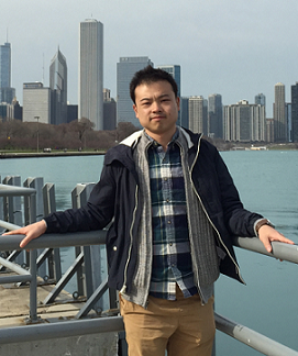 Man with back to railing, with city skyline in background