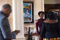 Two women having a conversation with a man looking on his cellphone