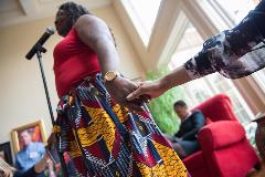 A woman giving a speech and holding someones hand